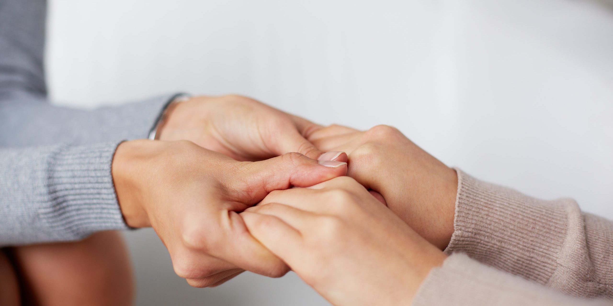 Close-up of psychiatrist hands holding those of her patient